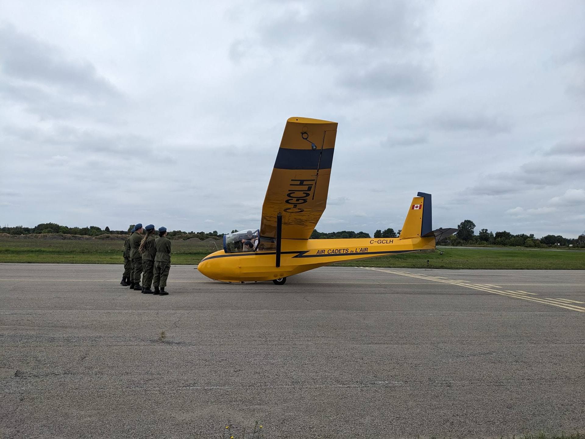 23 Squadron cadets beside a yellow Air Cadets glider on the flight line